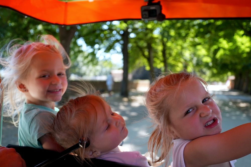 The three girls riding an electric pedal car along the top of Lucca's medieval walls, June 2022