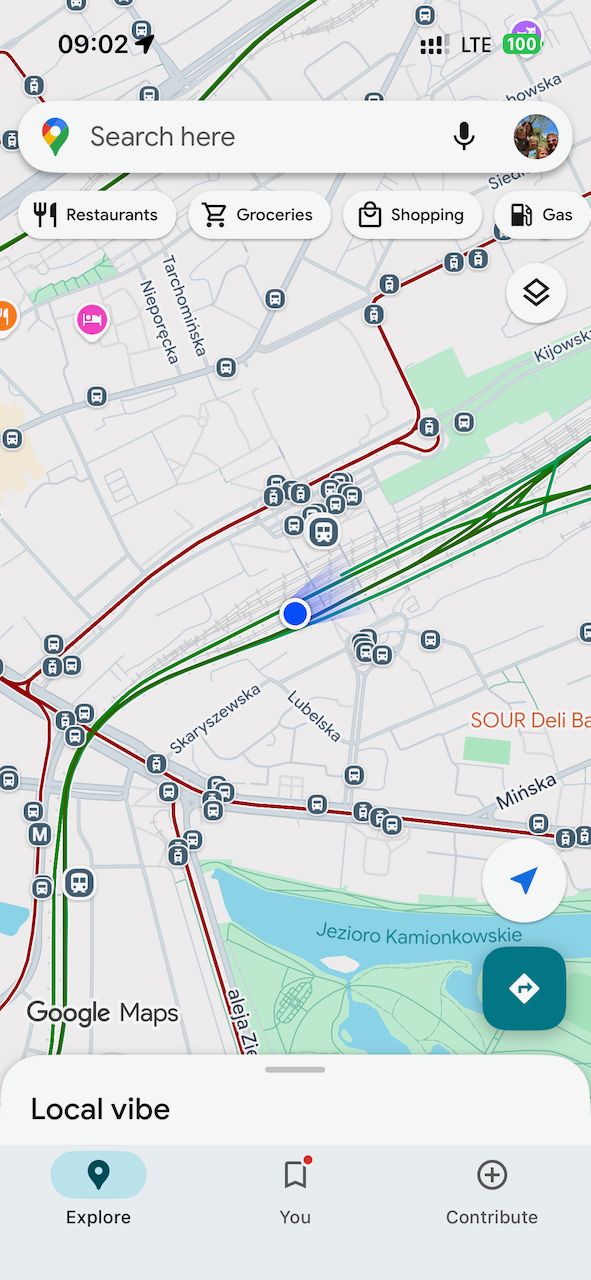A phone screenshot of Google Maps showing Warsaw transit lines with tram and train routes and a current location dot