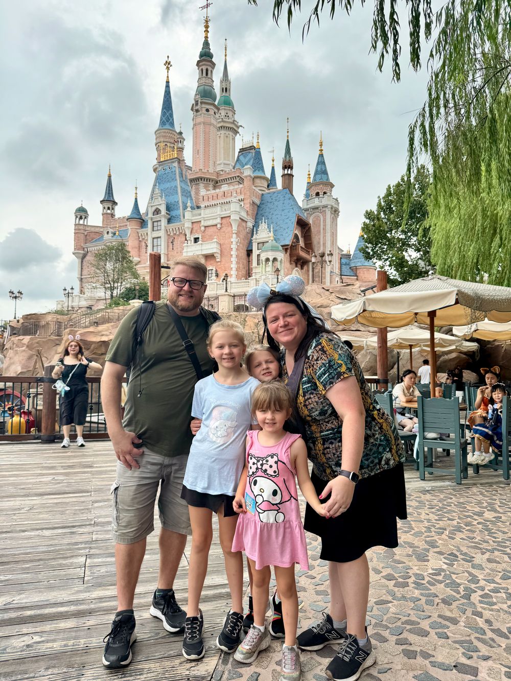 Adam, Lindsay, Cora, Harper, and Lily in front of the Enchanted Storybook Castle at Shanghai Disneyland, fall 2025