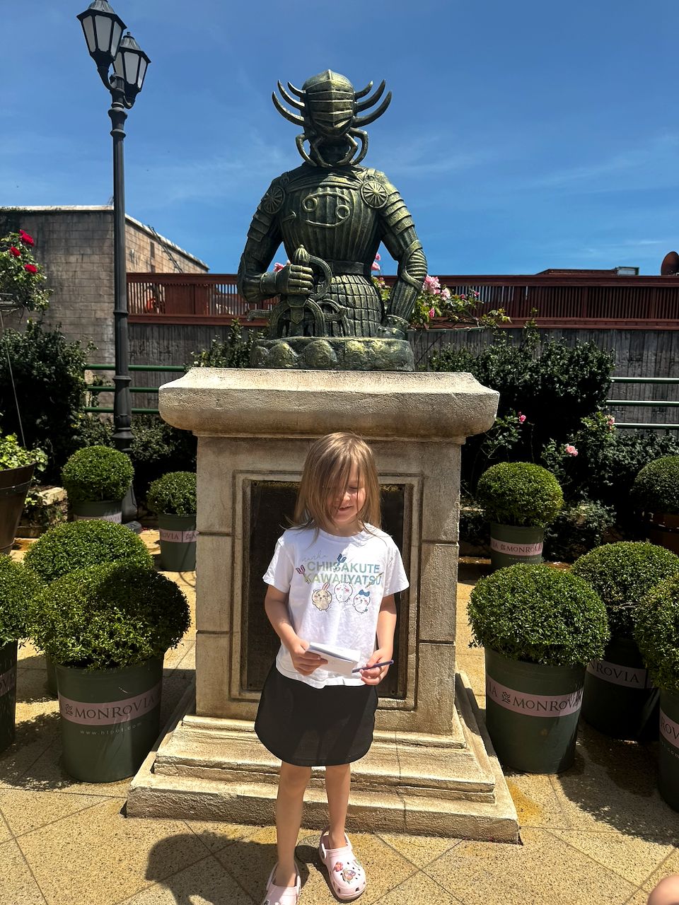 Harper with her notebook out in front of a bronze samurai statue at Ba Na Hills, Da Nang