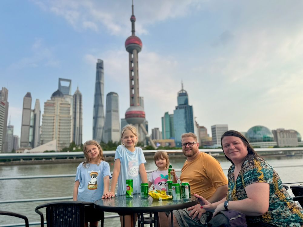 The family stands on the Bund with the Pudong skyline behind them in Shanghai, China